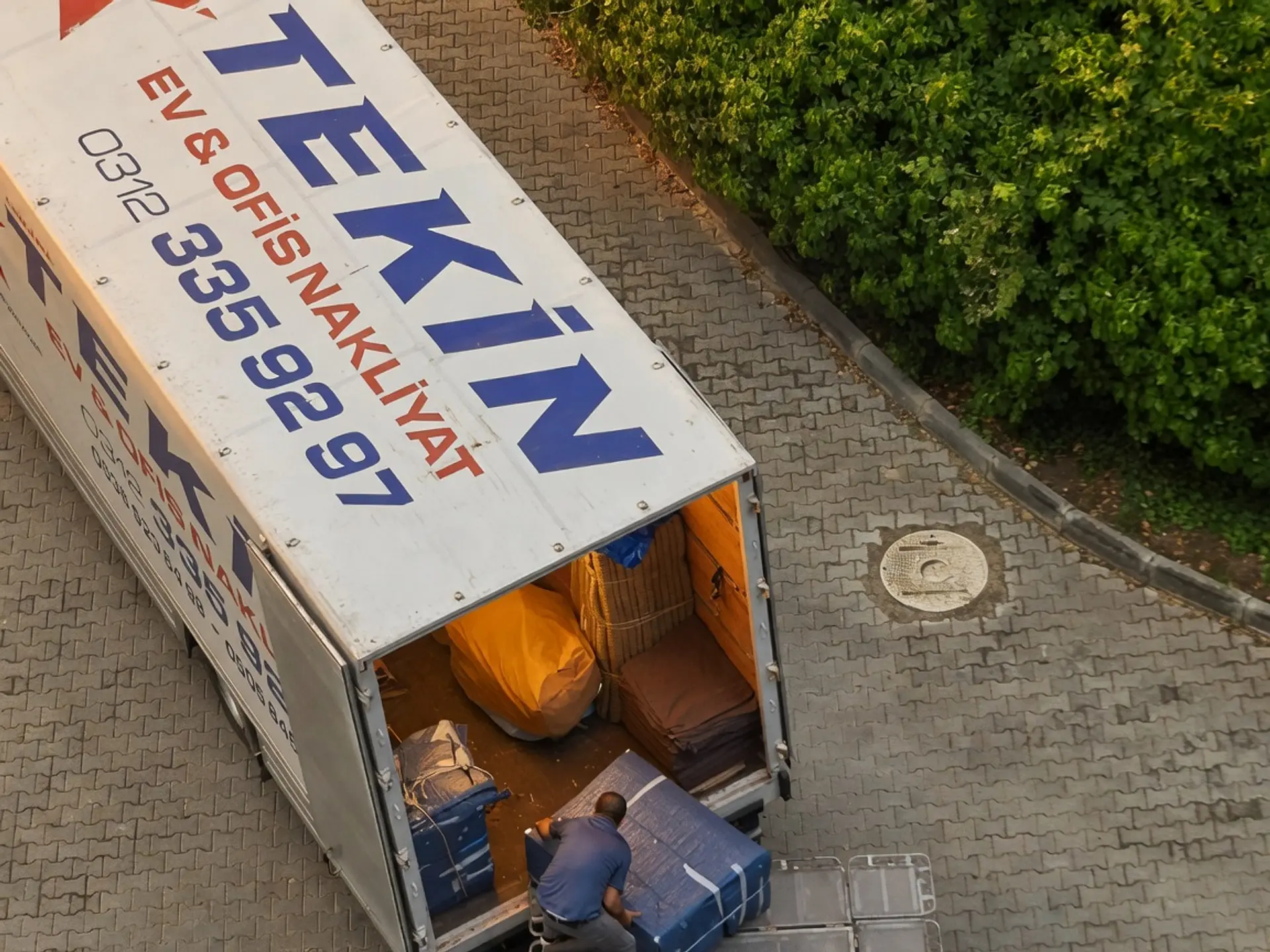 Kamyonun açık arka kasasına ambalajlı eşya yüklenirken üstten görünüm
