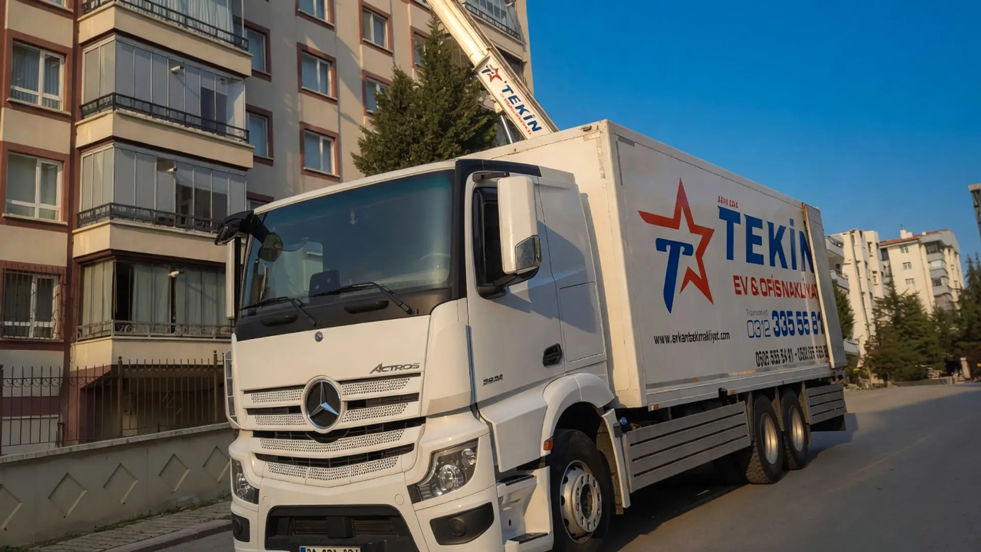 Tekin Nakliyat kamyonu apartman önünde, dış cephe taşıma asansörü üst katlara uzatılmış